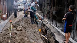 Equipe de obras conserta tubulação de água em via pública, foto de arquivo