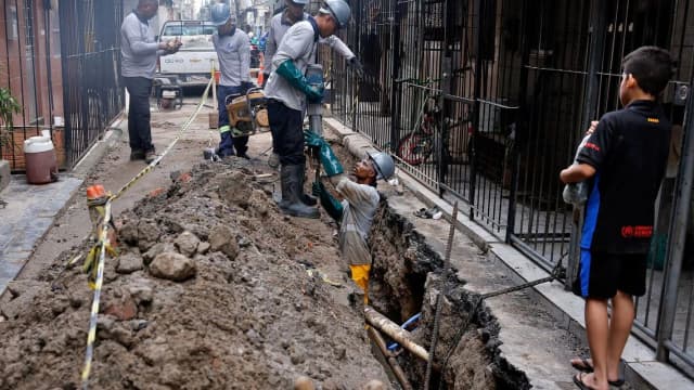 Equipe de obras conserta tubulação de água em via pública, foto de arquivo