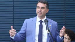 O senador Flávio Bolsonaro fala ao microfone durante evento