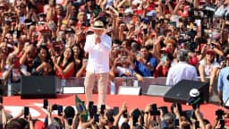 Lula discursa em palco vermelho cercado por apoiadores em primeiro ato de campanha