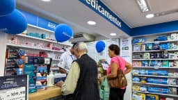 Cliente e atendente em farmácia, em foto de arquivo ilustrando o mercado de medicamentos