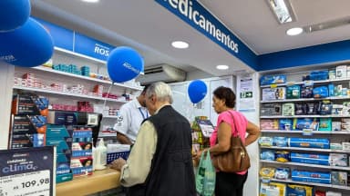 Cliente e atendente em farmácia, em foto de arquivo ilustrando o mercado de medicamentos