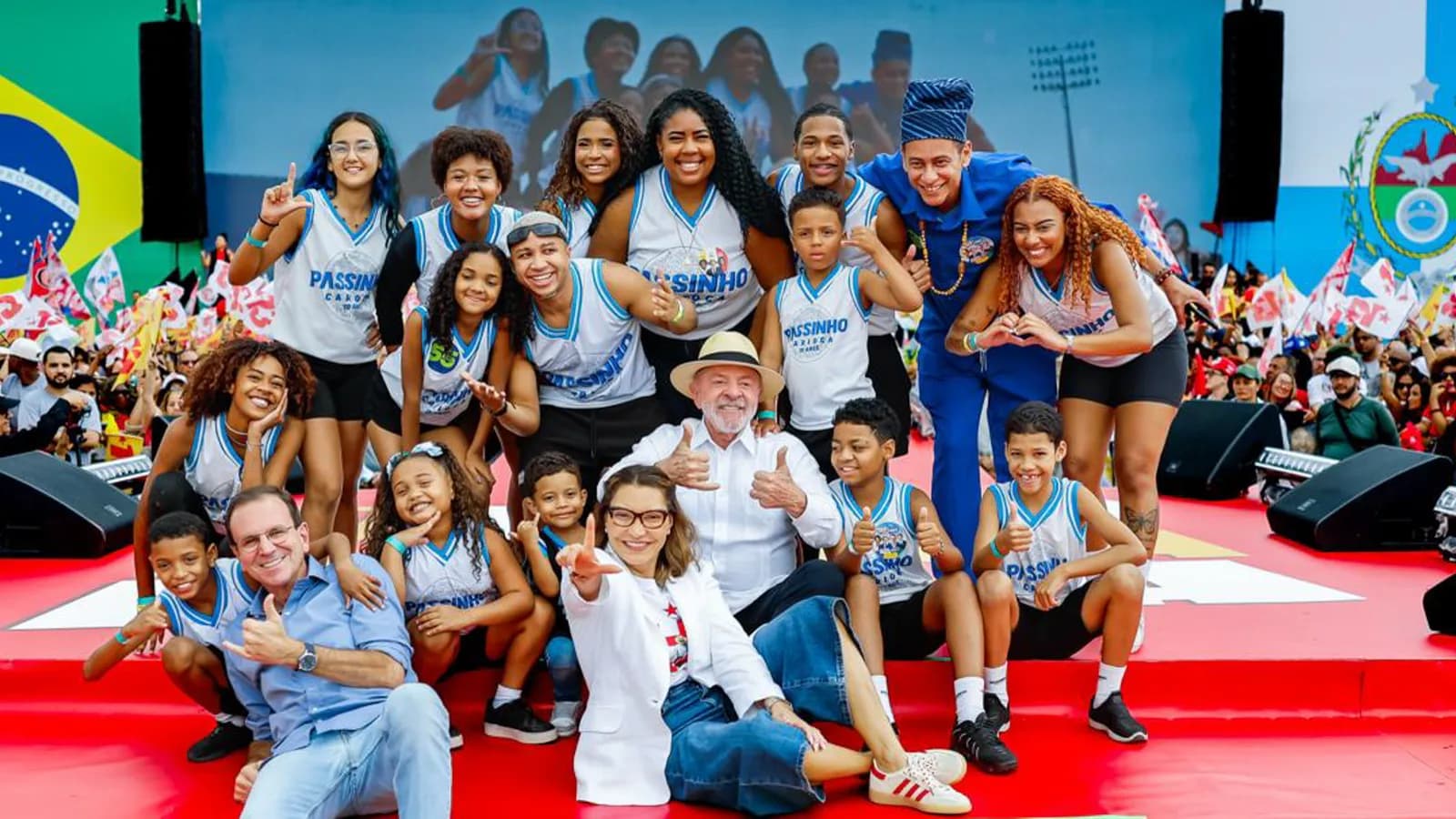 Lula discursa ao microfone em ato de campanha no Rio de Janeiro, com bandeira do Brasil ao fundo