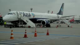Avião da Azul estacionado no pátio do Aeroporto de Guarulhos, com equipe de solo ao lado, foto de arquivo que ilustra o custo do combustível de aviação