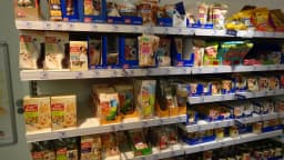 Prateleira de supermercado com embalagens de ração para cães e gatos