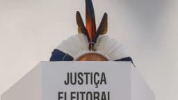 Cocar indígena sobre um púlpito com a inscrição 'Justiça Eleitoral'