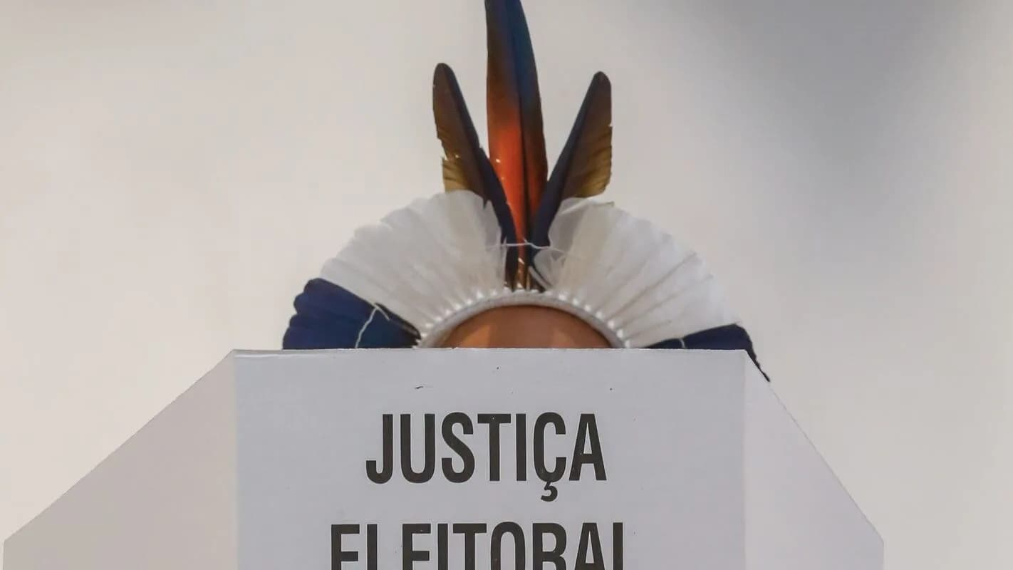 Cocar indígena sobre um púlpito com a inscrição 'Justiça Eleitoral'