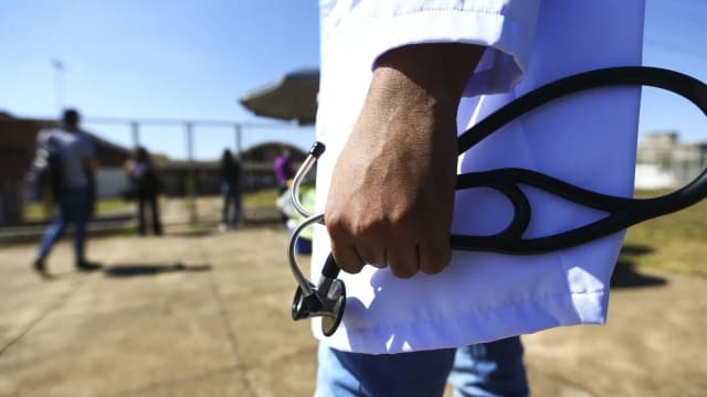 Candidato de concurso público caminha com material de prova, foto de arquivo