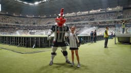 Mascote do Atlético-MG posa com torcedora mirim no gramado da Arena MRV