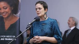 Mulher discursa em microfone durante evento ligado ao Ministério do Trabalho, foto de arquivo