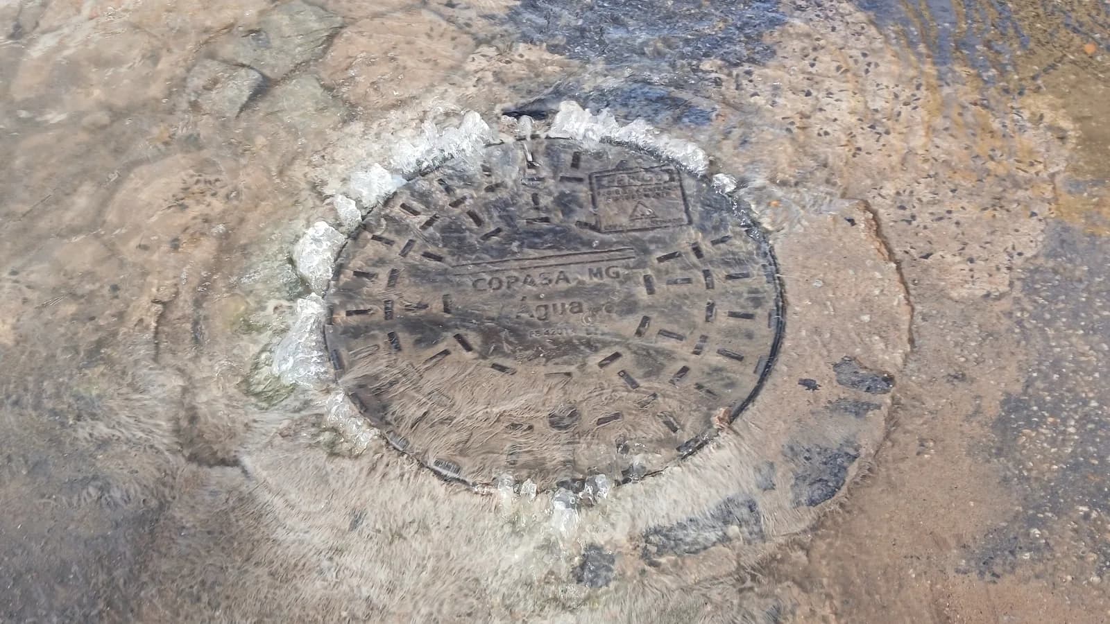 Bueiro de saneamento aberto em via pública, foto de contexto sobre risco de quedas em bueiros sem tampa