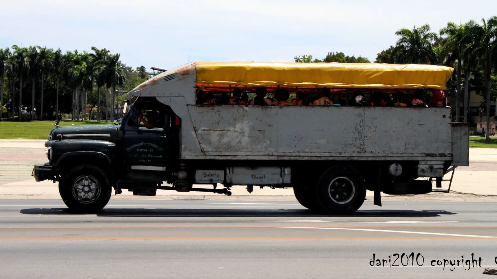 Caminhão adaptado como ônibus, lotado de passageiros, usado como transporte público em Cuba