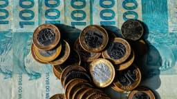Cédulas e moedas de real empilhadas