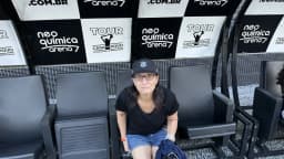 Torcedora sentada na arquibancada da Neo Química Arena, estádio do Corinthians