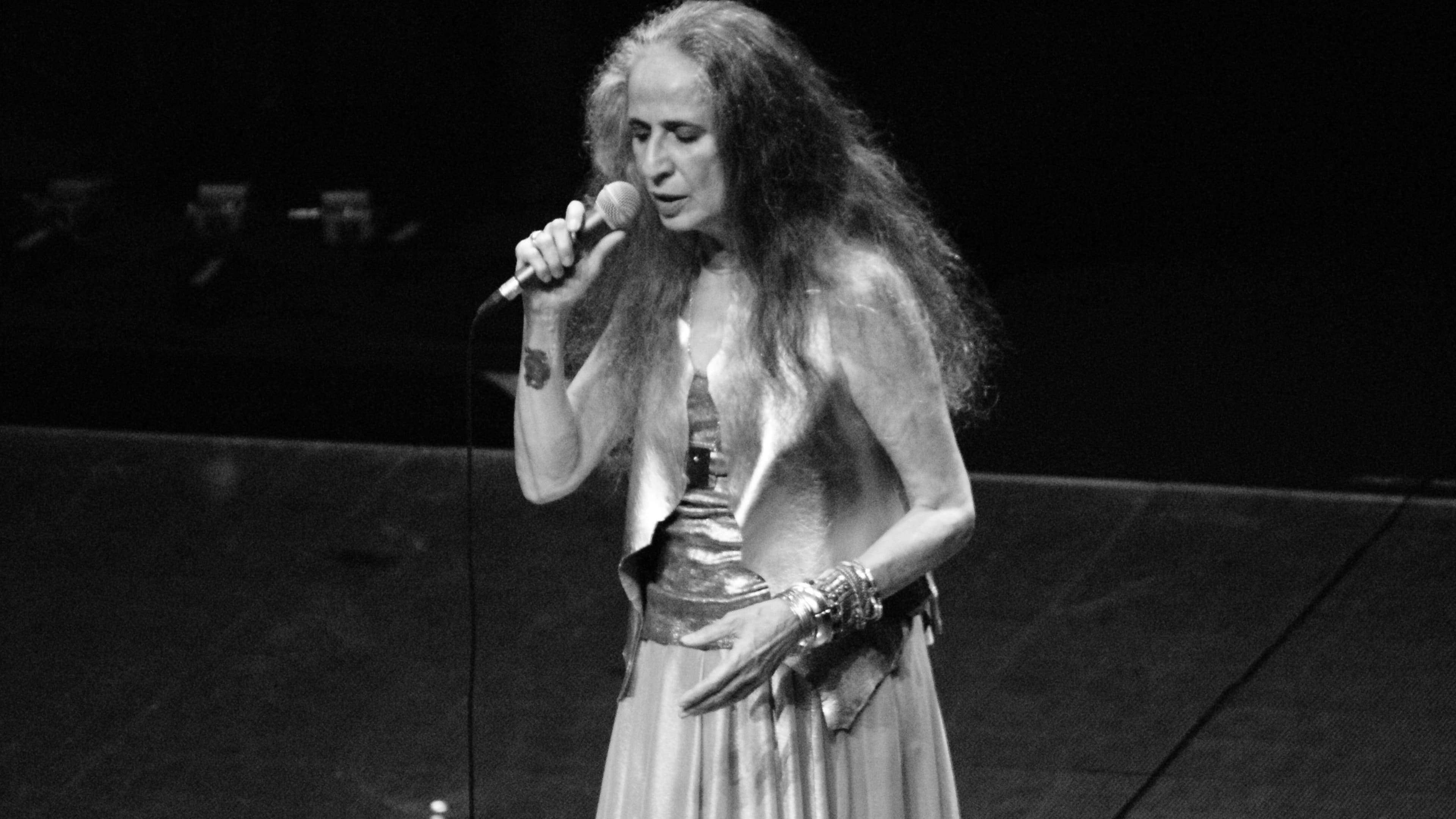 Maria Bethânia canta ao microfone em show, foto em preto e branco de arquivo de 2015