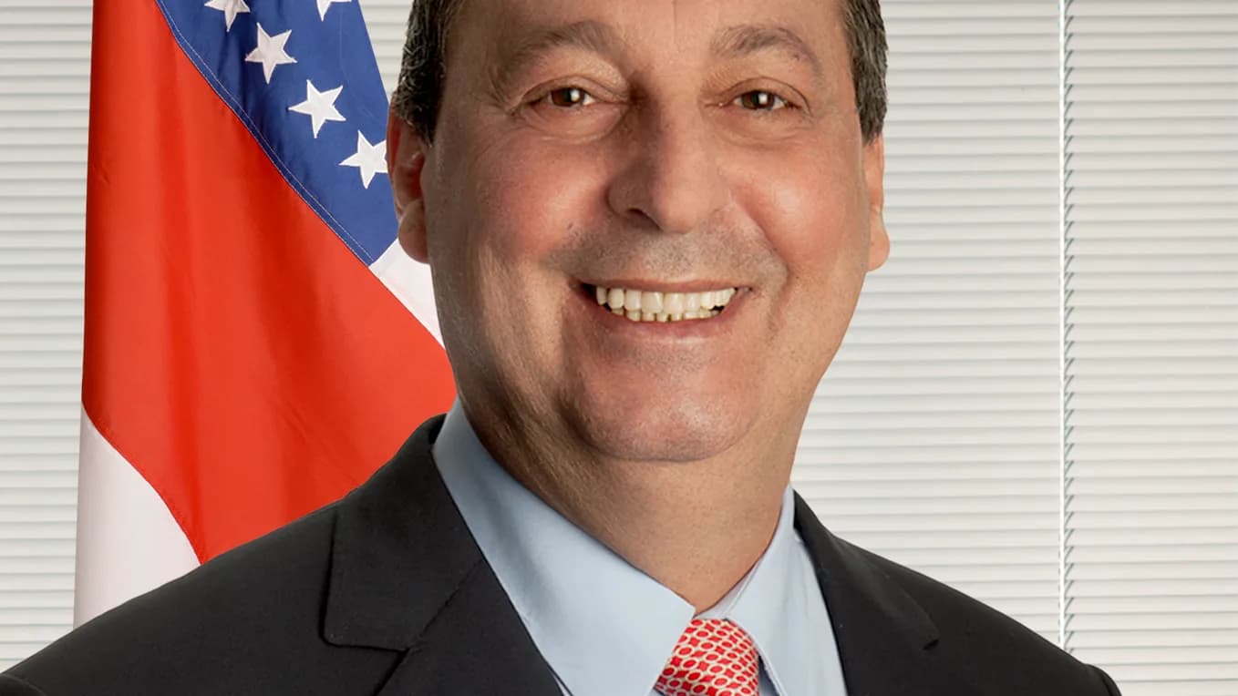 Retrato oficial do senador Omar Aziz (PSD-AM), sorrindo, de terno escuro e gravata vermelha