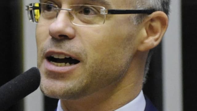 André Mendonça, de óculos e terno azul, fala ao microfone em discurso