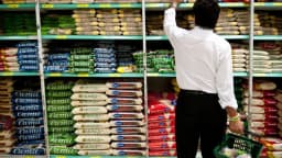 Consumidor escolhe alimentos em prateleira de supermercado, foto de arquivo