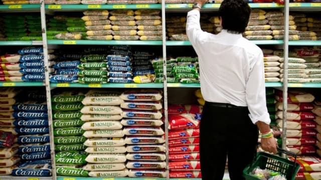 Consumidor escolhe alimentos em prateleira de supermercado, foto de arquivo