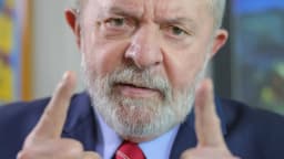 Lula em retrato oficial, de terno azul, gesticulando com as mãos