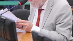 Patrus Ananias lê documento durante sessão de comissão na Câmara dos Deputados
