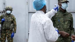 Profissional de saúde faz triagem de temperatura em militar durante resposta ao surto de Ebola