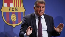 Joan Laporta gesticula durante entrevista coletiva com o escudo do Barcelona ao fundo