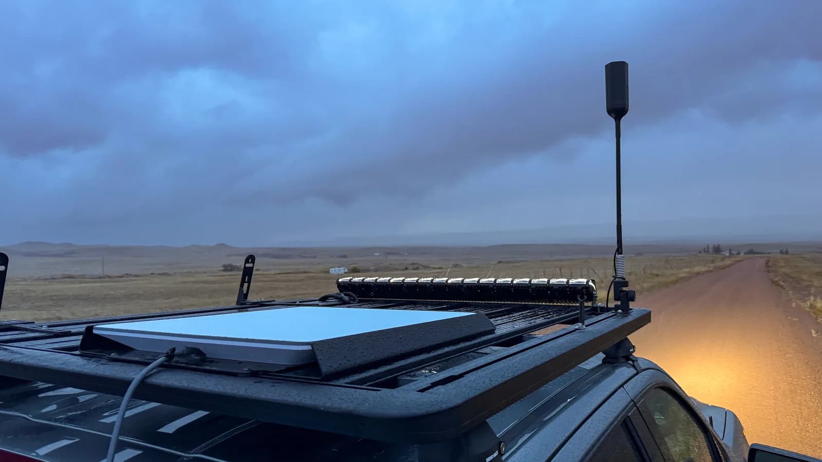 Antena da Starlink instalada no teto de um veículo em estrada de terra