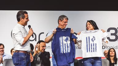 O governador de São Paulo, Tarcísio de Freitas, segura uma camiseta ao lado de outras pessoas em um palco durante evento do governo estadual em Araçatuba, em imagem de arquivo de setembro de 2025