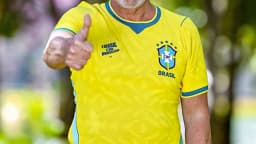 Lula sorri com os polegares para cima, vestindo camisa da Seleção Brasileira