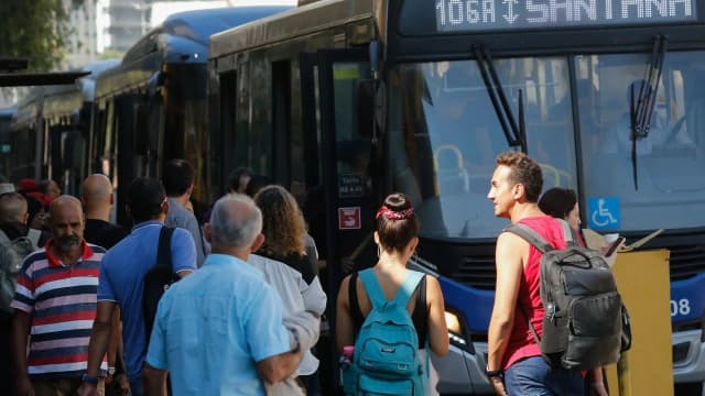 Passageiros embarcam em ônibus lotado em São Paulo