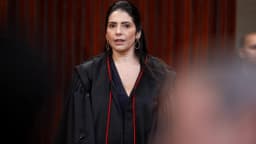 A ministra do TSE Estela Aranha, de toga preta com detalhes vermelhos, durante cerimônia de posse