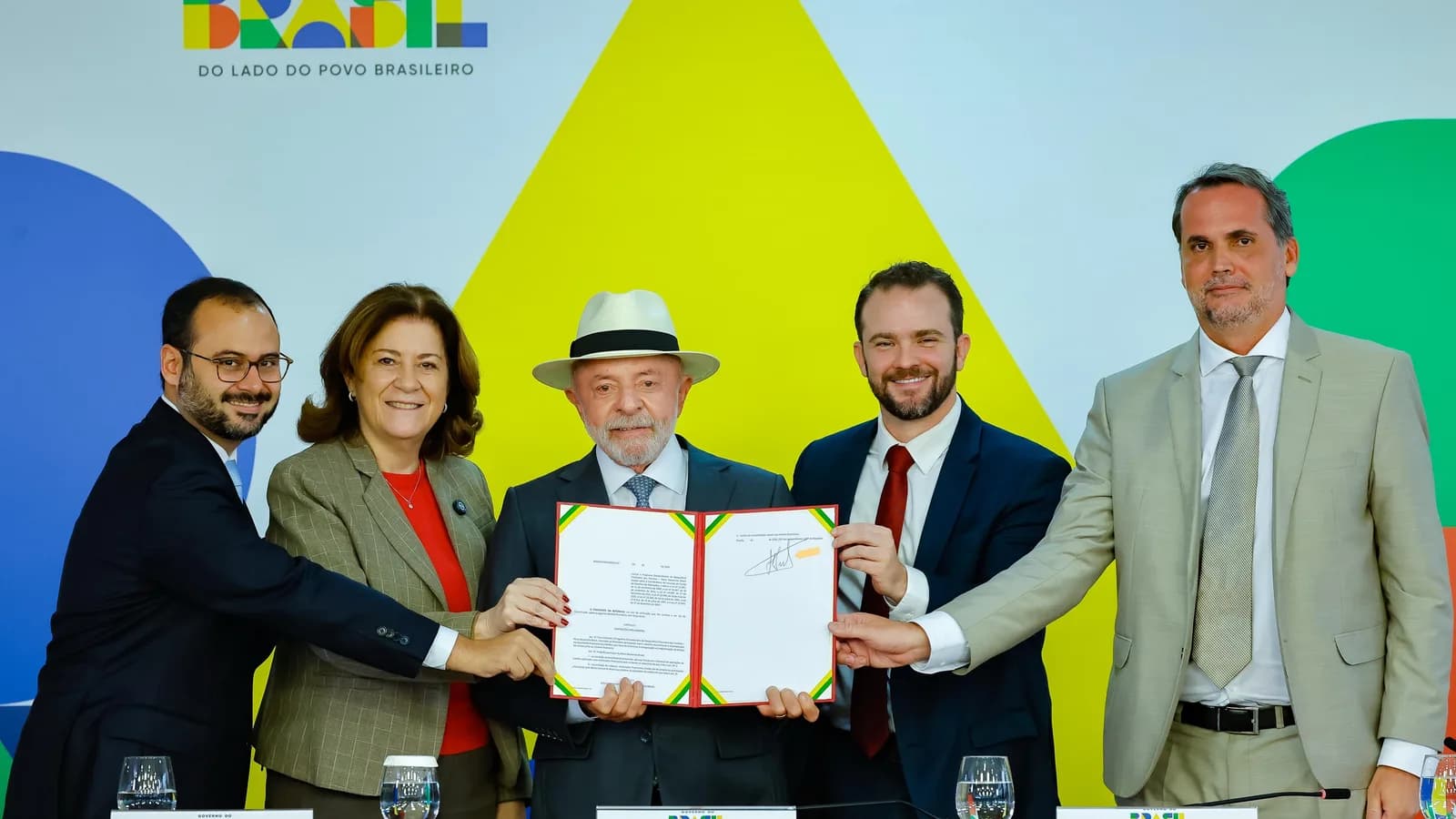 Lula e ministros seguram documento durante assinatura de medida provisória do Desenrola Brasil