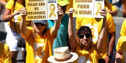 Participantes de caminhada do Setembro Amarelo seguram cartazes de incentivo à vida