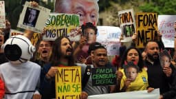 Manifestantes seguram cartazes contra a Meta em protesto em São Paulo, com faixas escritas Fora Meta e Soberania Digital