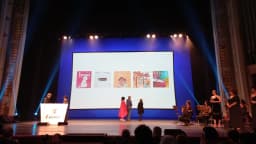 Palco de cerimônia do Prêmio Jabuti com plateia e telão exibindo capas de livros indicados