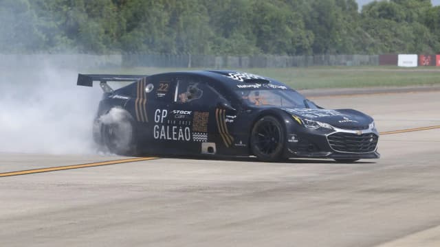 Carro da Stock Car brasileira em pista, com fumaça saindo dos pneus