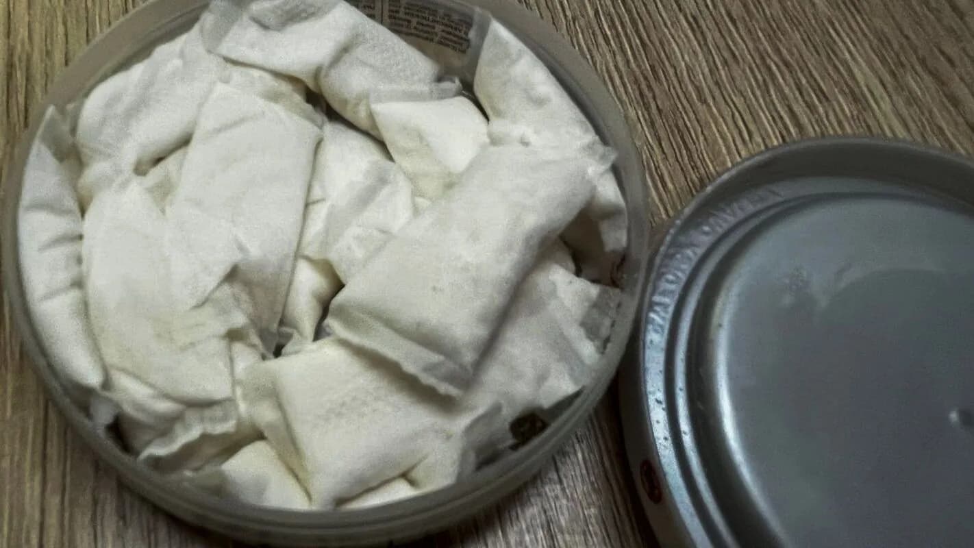 Lata aberta com sachês brancos de nicotina