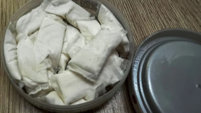 Lata aberta com sachês brancos de nicotina
