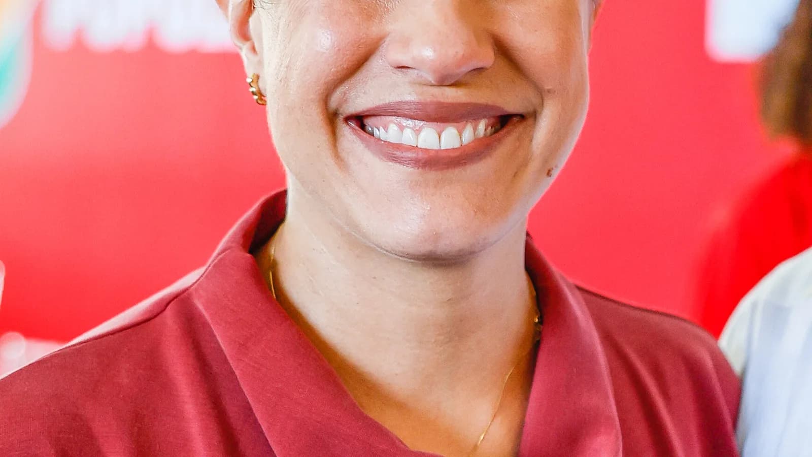 Raquel Lyra sorri em retrato, usando vestido vermelho