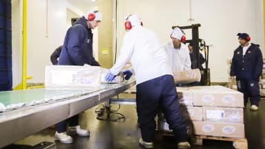 Trabalhadores embalam caixas de frango em linha de produção para exportação, foto de arquivo