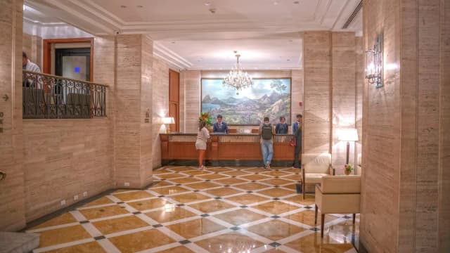Lobby do Copacabana Palace, no Rio de Janeiro, com hóspedes e recepcionistas