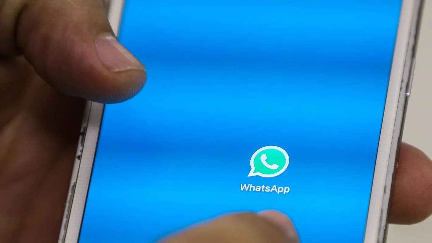 Mão segurando celular com aplicativo WhatsApp aberto (foto ilustrativa)