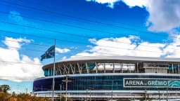 Fachada da Arena do Grêmio em Porto Alegre, sob céu azul