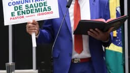 Pastor Sargento Isidório discursa no plenário da Câmara dos Deputados segurando cartaz e Bíblia