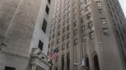 Fachada da Bolsa de Nova York (NYSE), em Wall Street, com a bandeira dos Estados Unidos