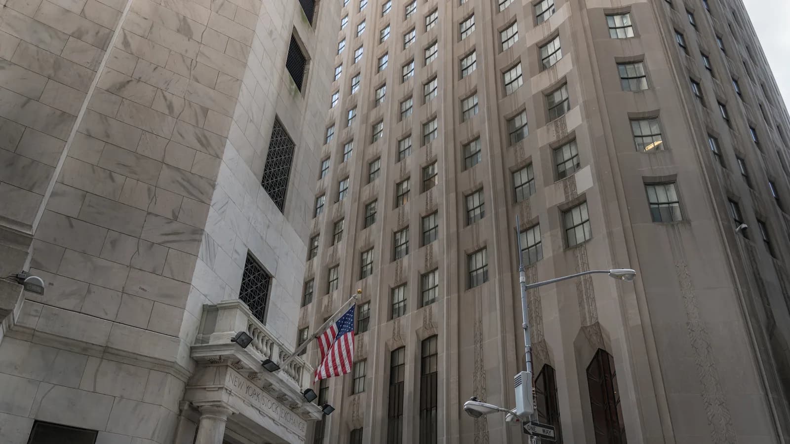 Fachada da Bolsa de Nova York (NYSE), em Wall Street, com a bandeira dos Estados Unidos