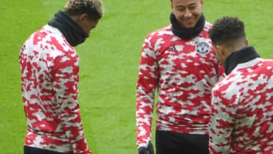 Jesse Lingard sorri ao lado de companheiros durante aquecimento em campo