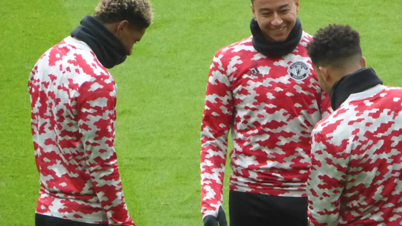 Jesse Lingard sorri ao lado de companheiros durante aquecimento em campo
