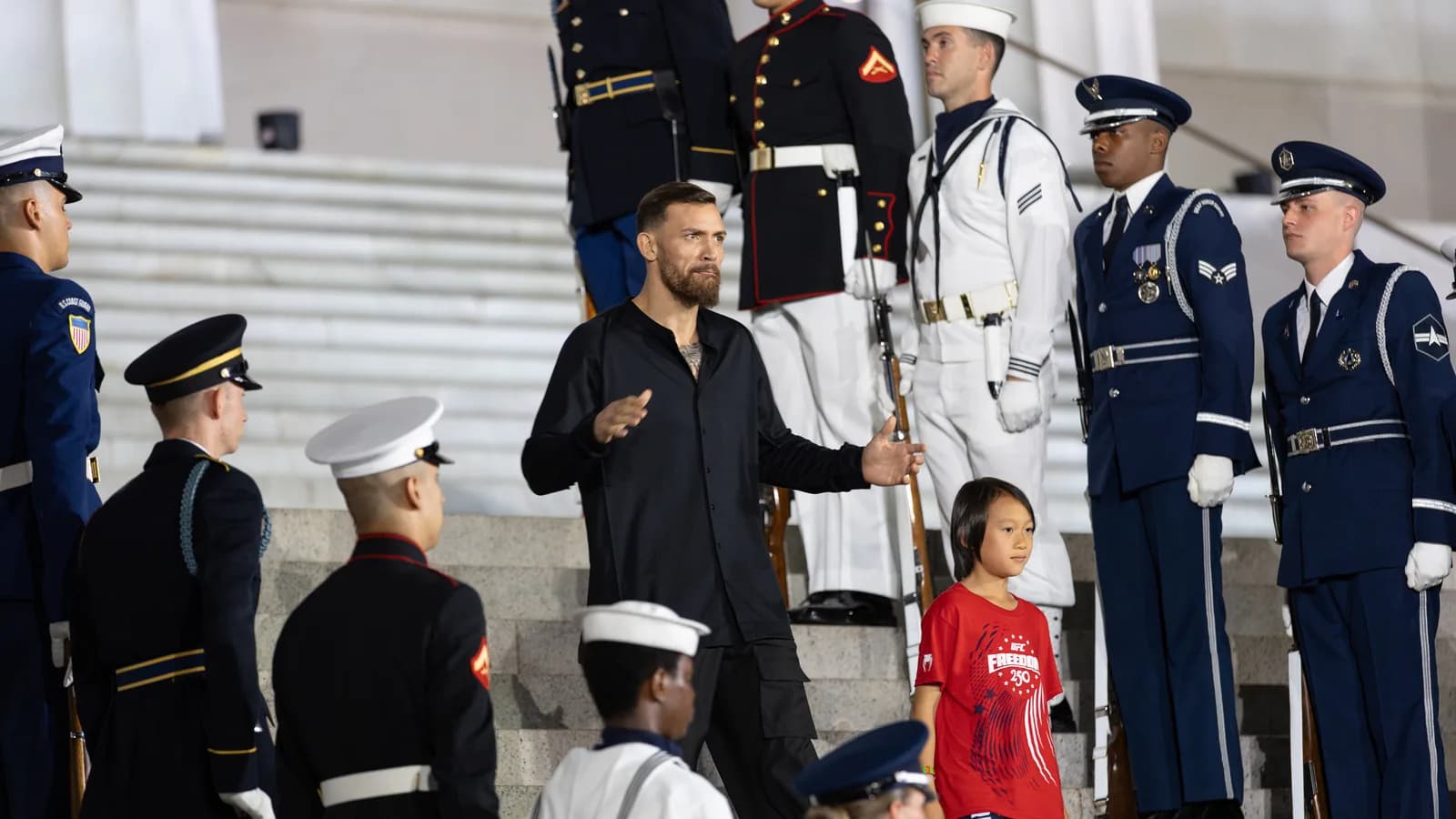 Mauricio Ruffy desce escadaria cercado por guarda de honra militar durante evento do UFC nos Estados Unidos